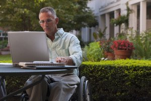man in wheelchair on laptop